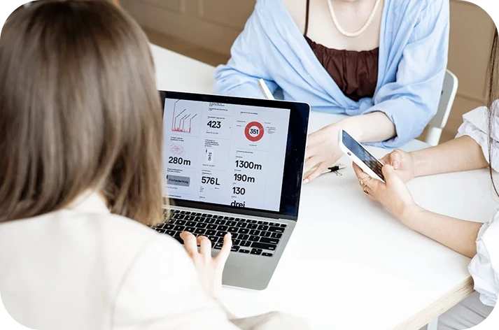 Professionals using a laptop to monitor real-time marketing performance metrics and ROI data.